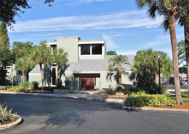 contemporary house with a shingled roof and stucco siding