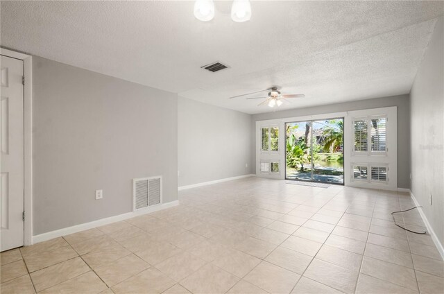 spare room featuring visible vents, a textured ceiling, ceiling fan, and baseboards