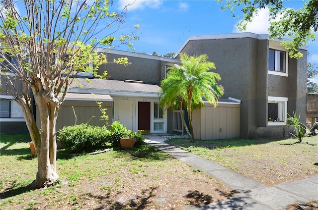 view of front facade featuring stucco siding and a front yard