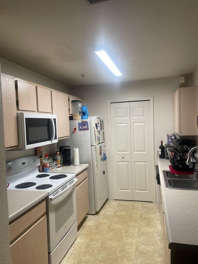 5471 Vineland Rd Unit 7108, Orlando, FL 32811 - kitchen with light countertops, light brown cabinets, a sink, and white range with electric cooktop