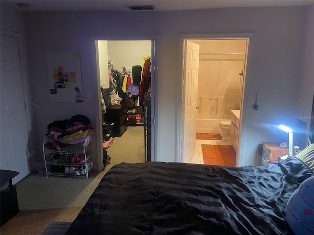 5471 Vineland Rd Unit 7108, Orlando, FL 32811 - bedroom with a closet, light carpet, a spacious closet, ensuite bath, and visible vents