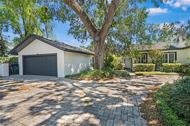 1701 Palmer Ave, Winter Park, FL 32789 - exterior space with stucco siding, decorative driveway, an outdoor structure, and fence