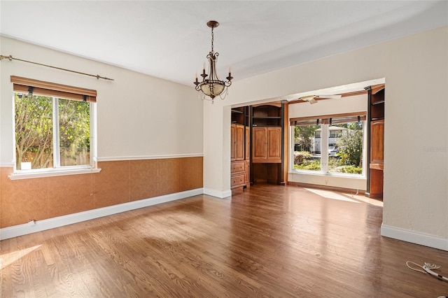 1701 Palmer Ave, Winter Park, FL 32789 - spare room featuring ceiling fan with notable chandelier, a wainscoted wall, wood finished floors, and baseboards