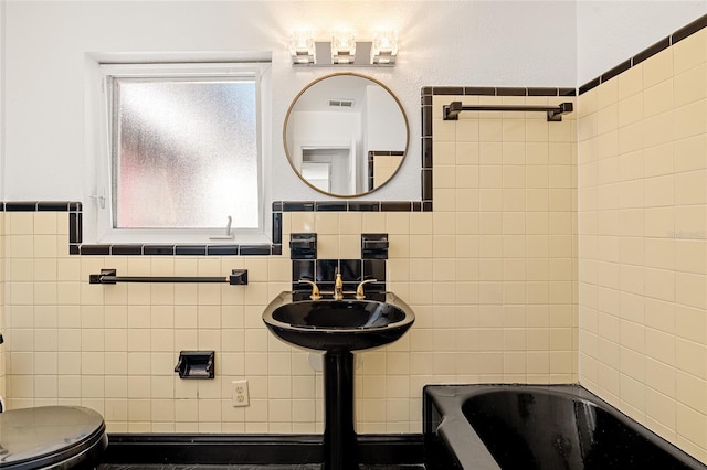 1701 Palmer Ave, Winter Park, FL 32789 - bathroom with visible vents, toilet, tile walls, and a sink