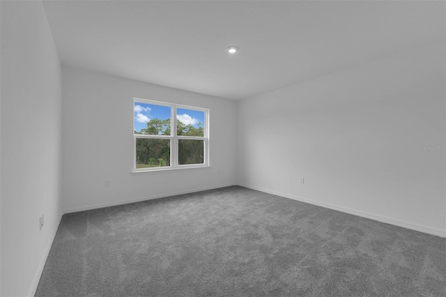 carpeted empty room featuring baseboards