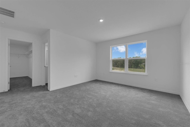 unfurnished room with visible vents, baseboards, and carpet flooring