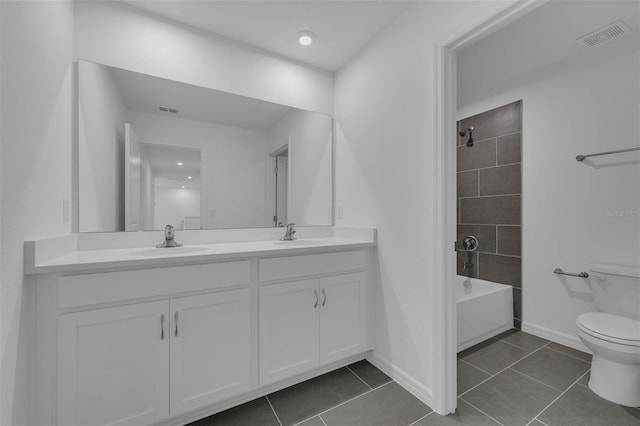bathroom with tile patterned floors, toilet, double vanity, and a sink