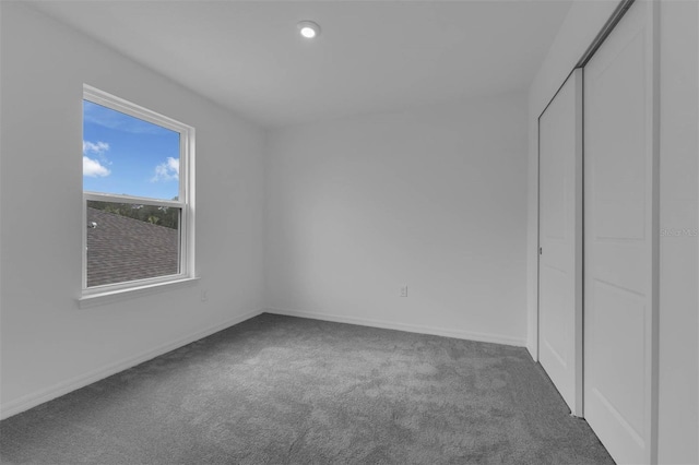 unfurnished bedroom with a closet, baseboards, and carpet flooring