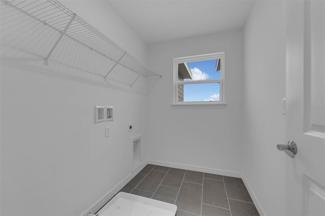 laundry area featuring baseboards, dark tile patterned floors, laundry area, hookup for a washing machine, and electric dryer hookup