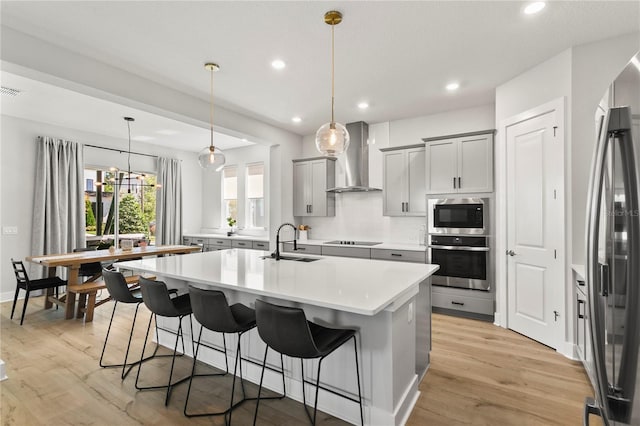 14004 Gullstrand Ave, Orlando, FL 32827 - kitchen with gray cabinets, a sink, wall chimney exhaust hood, a center island with sink, and stainless steel appliances
