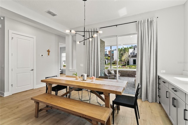 14004 Gullstrand Ave, Orlando, FL 32827 - dining room featuring baseboards, visible vents, light wood-style flooring, and a notable chandelier