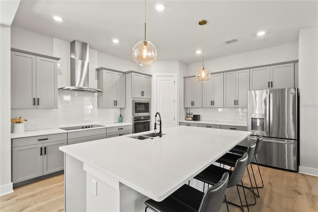 14004 Gullstrand Ave, Orlando, FL 32827 - kitchen with gray cabinetry, visible vents, wall chimney range hood, and appliances with stainless steel finishes