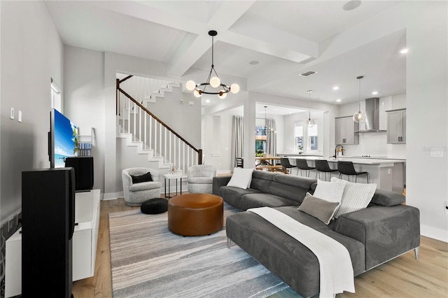 14004 Gullstrand Ave, Orlando, FL 32827 - living area with stairs, a chandelier, beamed ceiling, light wood-style floors, and visible vents