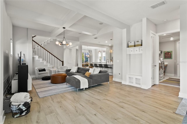 14004 Gullstrand Ave, Orlando, FL 32827 - living room with visible vents, a chandelier, beamed ceiling, stairs, and light wood-type flooring