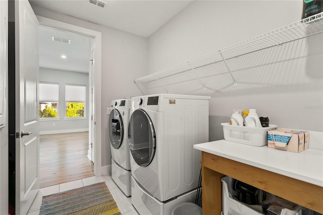 14004 Gullstrand Ave, Orlando, FL 32827 - laundry room featuring visible vents, independent washer and dryer, baseboards, laundry area, and light tile patterned floors