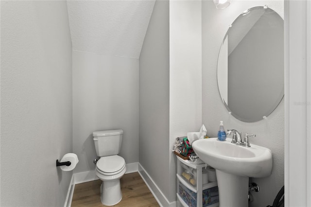 14004 Gullstrand Ave, Orlando, FL 32827 - bathroom with vaulted ceiling, toilet, baseboards, a textured ceiling, and wood finished floors