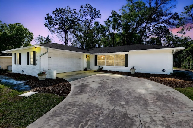 ranch-style home featuring stucco siding, driveway, and an attached garage