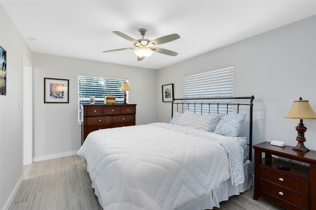 bedroom featuring wood finished floors, baseboards, and ceiling fan