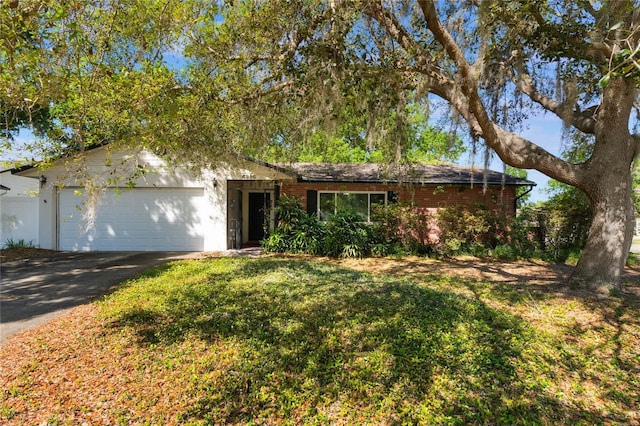 4366 Roanne Dr, Orlando, FL 32817 - ranch-style house with brick siding, driveway, a front yard, and an attached garage