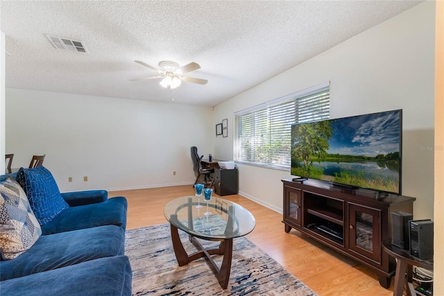 4366 Roanne Dr, Orlando, FL 32817 - living area featuring baseboards, visible vents, light wood finished floors, ceiling fan, and a textured ceiling