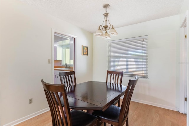 4366 Roanne Dr, Orlando, FL 32817 - dining room with light wood-style floors, baseboards, and a notable chandelier