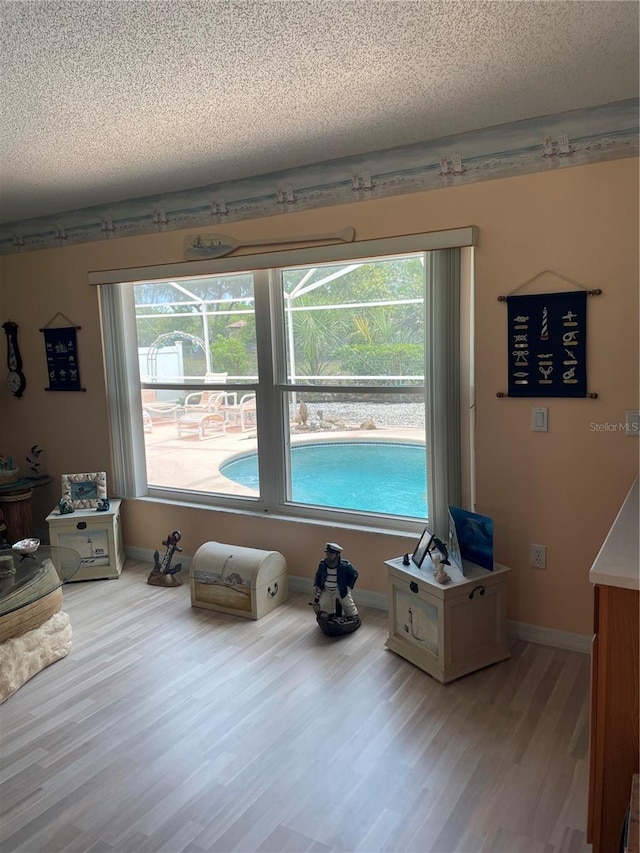 miscellaneous room with a textured ceiling, wood finished floors, and baseboards