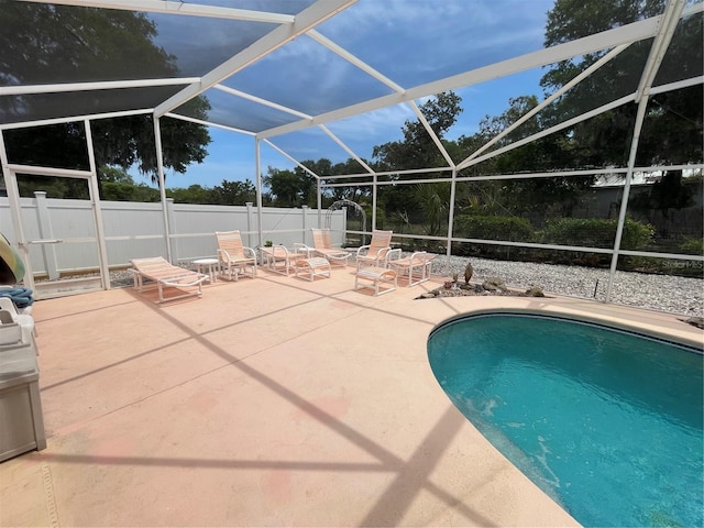 view of pool with a patio, a fenced in pool, a fenced backyard, and glass enclosure