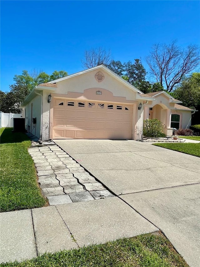 view of front facade with a front yard, stucco siding, driveway, and a garage