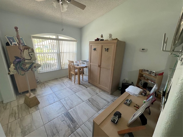 interior space with a ceiling fan, marble finish floor, and a textured ceiling