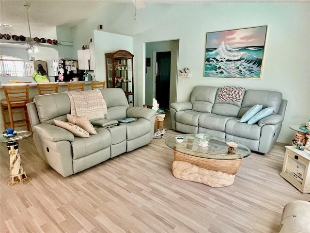 living area featuring a ceiling fan, light wood-style floors, and lofted ceiling