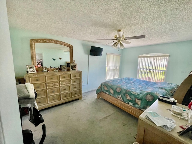 bedroom with a textured ceiling, ceiling fan, and carpet floors