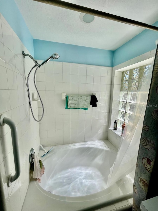 bathroom featuring tiled shower / bath combo and a textured ceiling