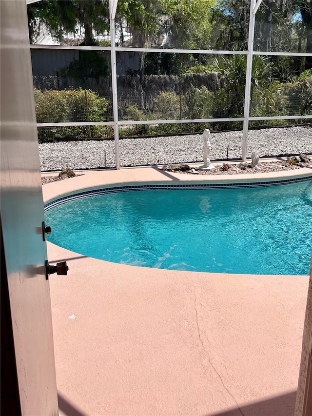 outdoor pool featuring a lanai and fence