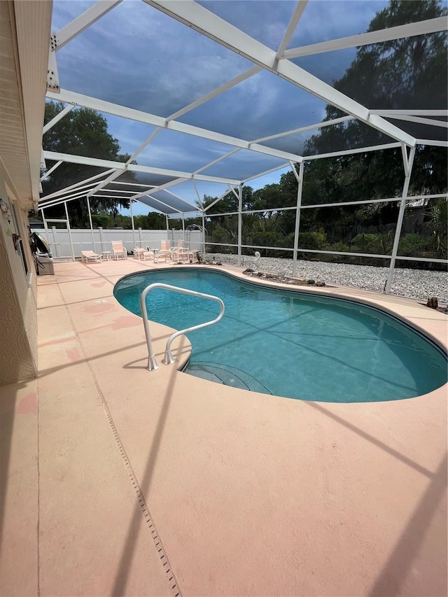 view of swimming pool with a patio area, a fenced in pool, fence, and a lanai