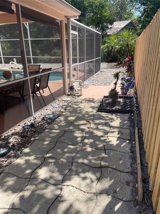 view of patio featuring fence private yard, glass enclosure, and an outdoor pool