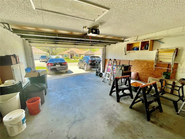 garage featuring concrete block wall and a garage door opener