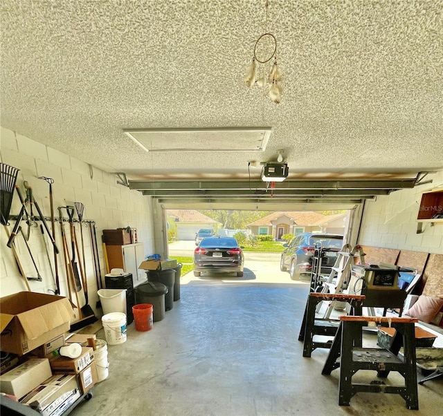 garage with concrete block wall and a garage door opener