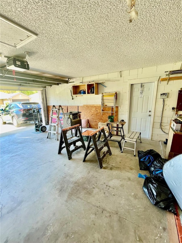 garage featuring a garage door opener and concrete block wall