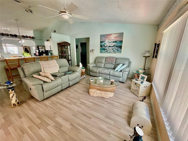 6037 Hickory Grove Ln, Port Orange, FL 32128 - living area featuring vaulted ceiling, ceiling fan, a textured ceiling, and light wood-type flooring