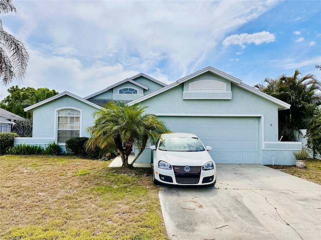72 Saint Kitts Cir, Winter Haven, FL 33884 - view of front of property featuring concrete driveway, a garage, stucco siding, and a front yard