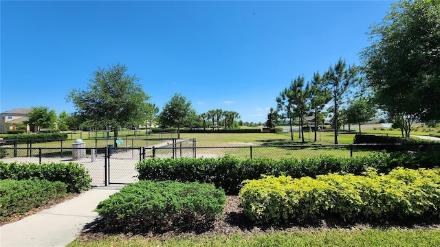 view of property's community featuring fence, a lawn, and a gate