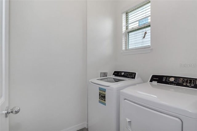 clothes washing area with washer and clothes dryer and laundry area