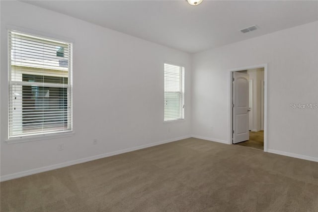 carpeted spare room with baseboards and visible vents
