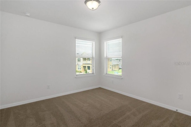 carpeted spare room featuring baseboards