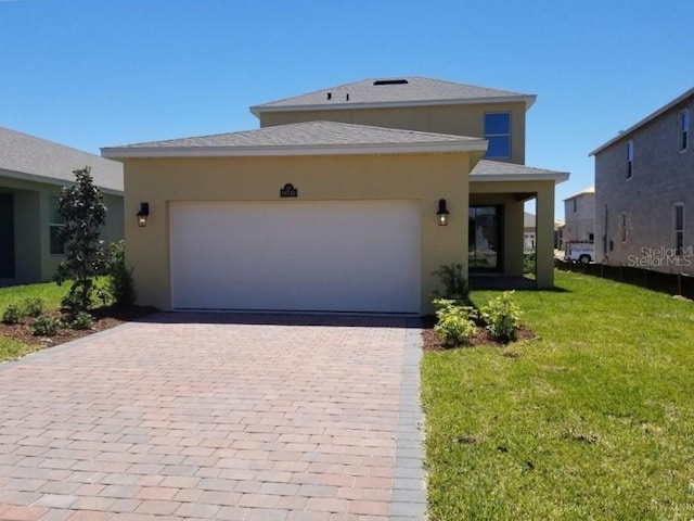view of front of property featuring decorative driveway, a front yard, a garage, stucco siding, and roof with shingles