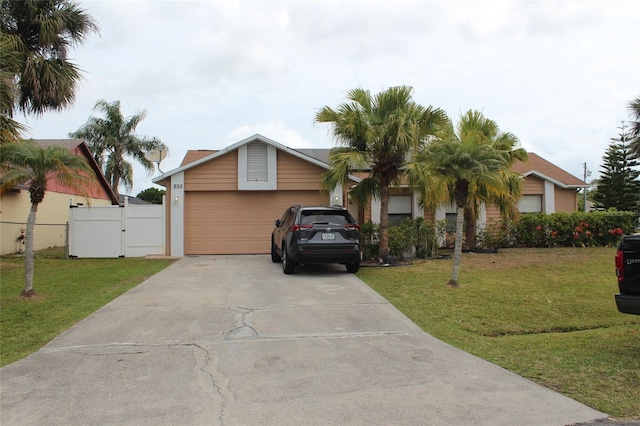 855 San Pedro Ct, Kissimmee, FL 34758 - view of front facade featuring a front yard, a gate, a garage, and driveway