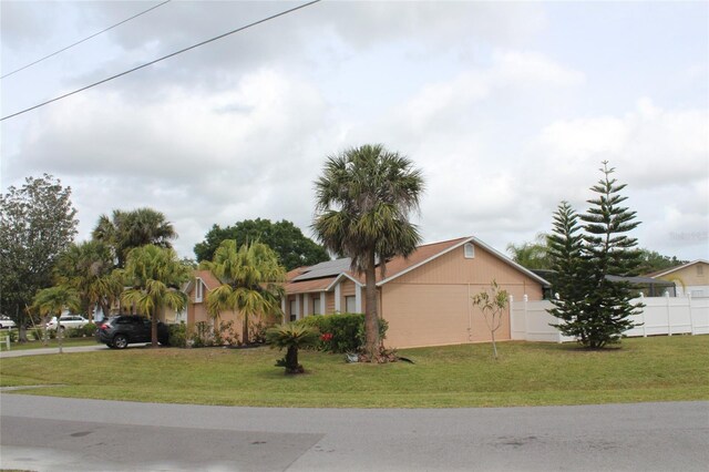 855 San Pedro Ct, Kissimmee, FL 34758 - view of front of house featuring solar panels, fence, and a front yard