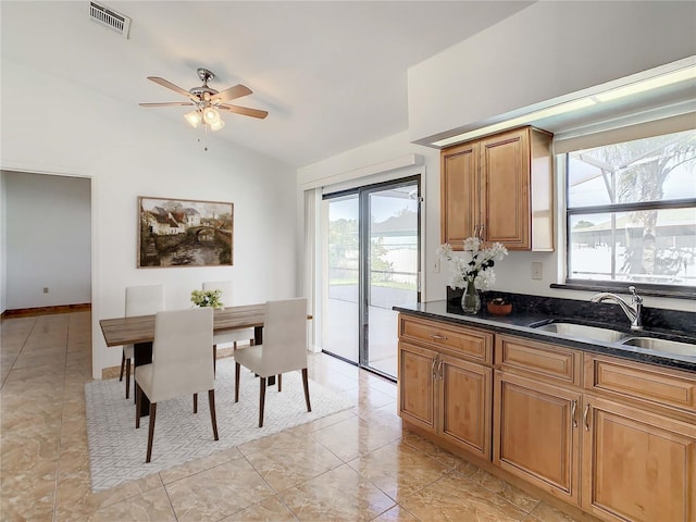 855 San Pedro Ct, Kissimmee, FL 34758 - kitchen featuring visible vents, brown cabinets, a ceiling fan, a sink, and vaulted ceiling