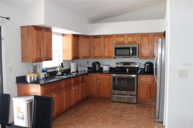 855 San Pedro Ct, Kissimmee, FL 34758 - kitchen featuring lofted ceiling, dark countertops, brown cabinetry, and appliances with stainless steel finishes