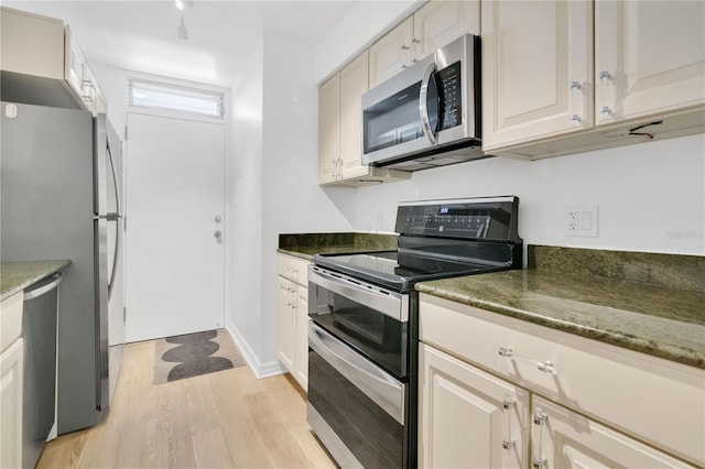 700 Melrose Ave Unit L-23, Winter Park, FL 32789 - kitchen featuring light wood-style flooring, dark stone counters, and appliances with stainless steel finishes